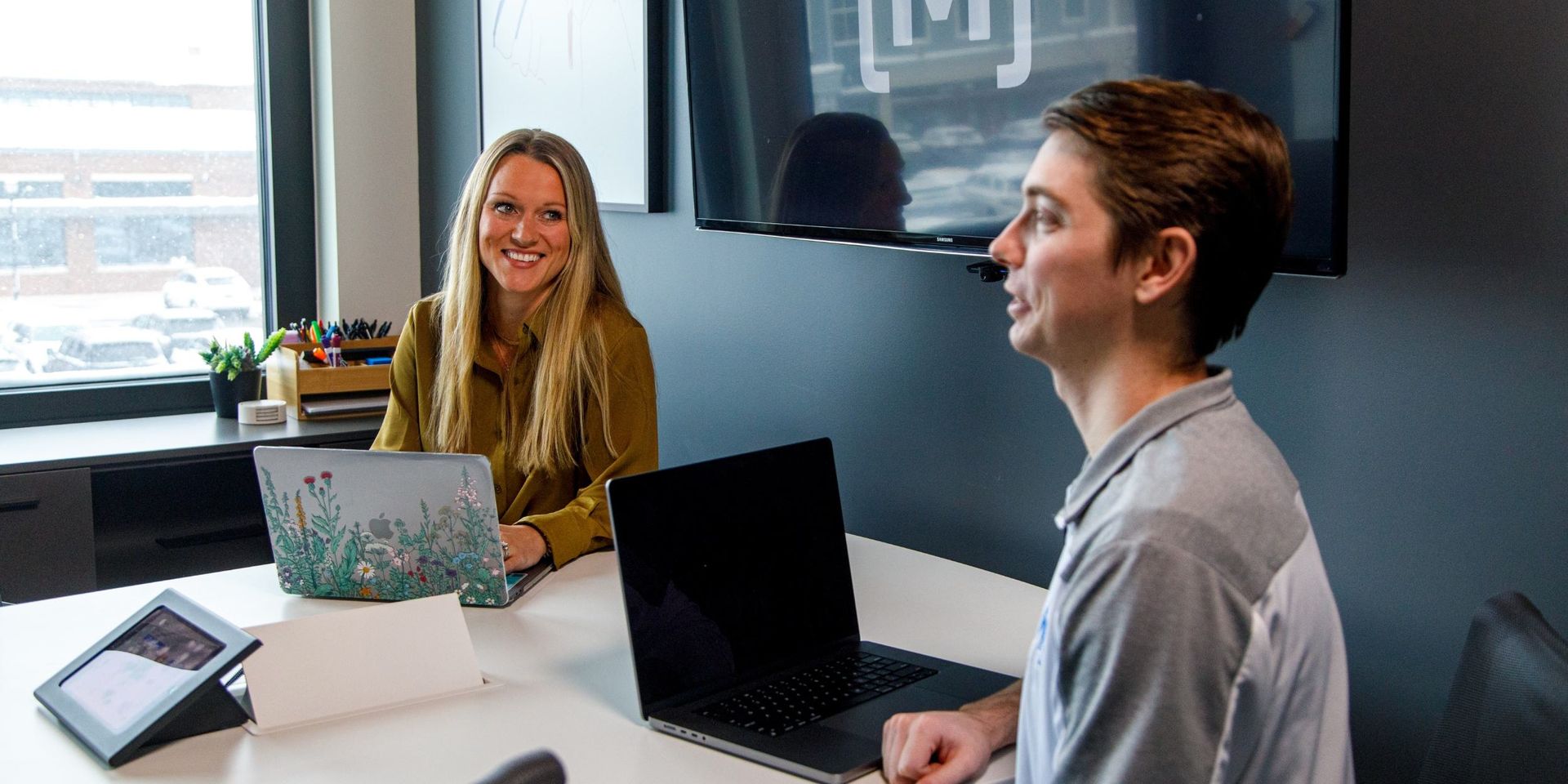 two co-workers smiling