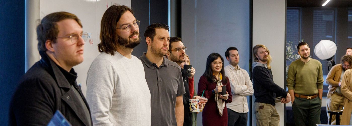 team members stand for weekly check-in meeting